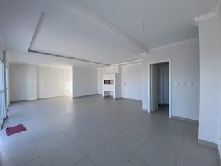 Sala ampla com piso de cerâmica e paredes brancas.