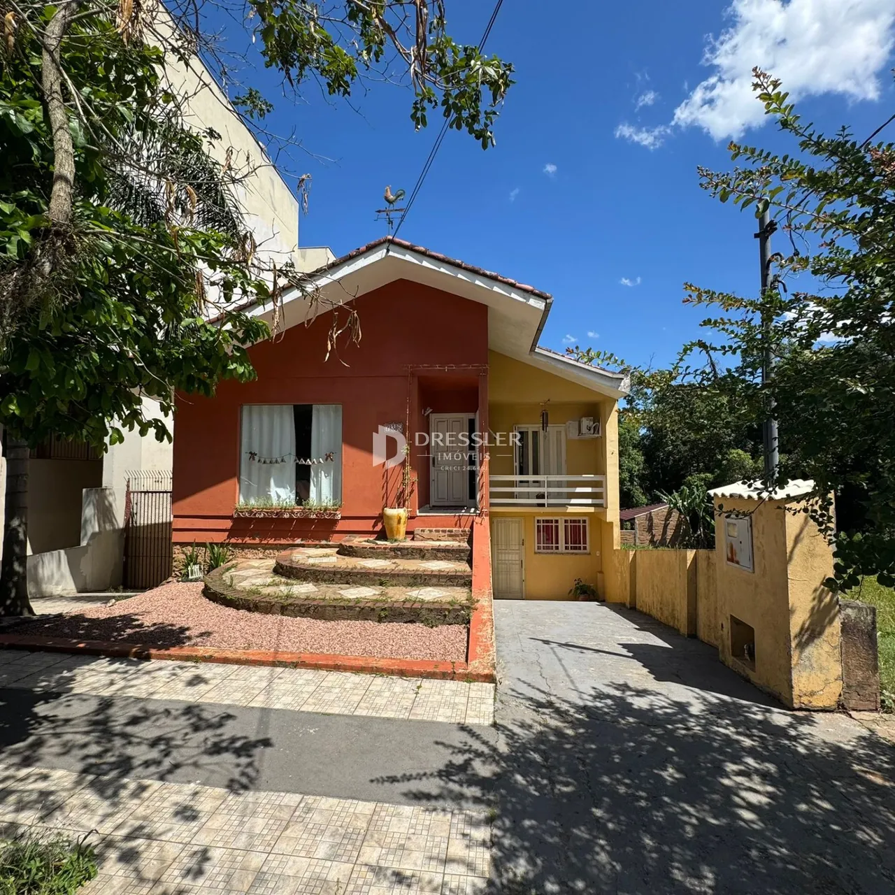 Fachada de uma residência em Lajeado, Brasil, com jardim e muro lateral.