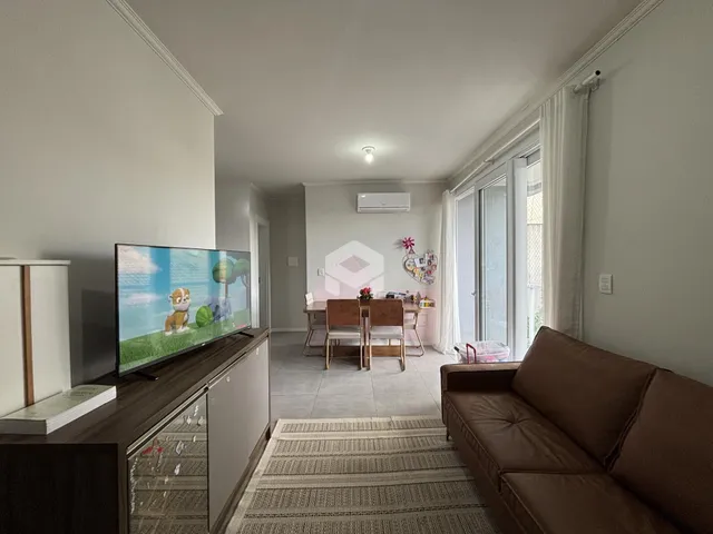 Sala de estar com televisão e sofá em um apartamento no Brasil.