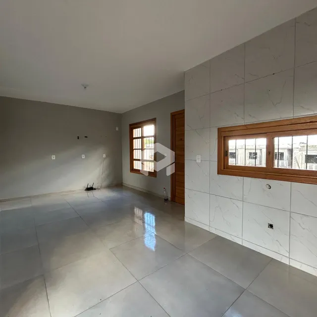 Ambiente interno amplo com piso de cerâmica e paredes em tom neutro.