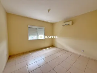 Sala de estar com piso de cerâmica e janela com persianas.