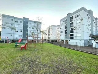 Vista externa de um complexo de apartamentos em Lajeado, Brasil, com área verde e playground.
