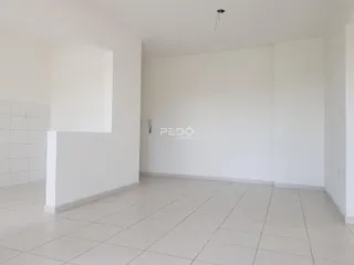 Ambiente interno de uma sala com piso de cerâmica e paredes brancas.