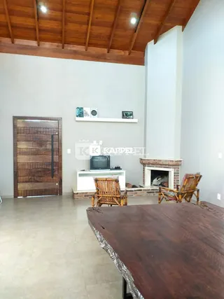 Ambiente interno com teto de madeira e lareira em uma residência.