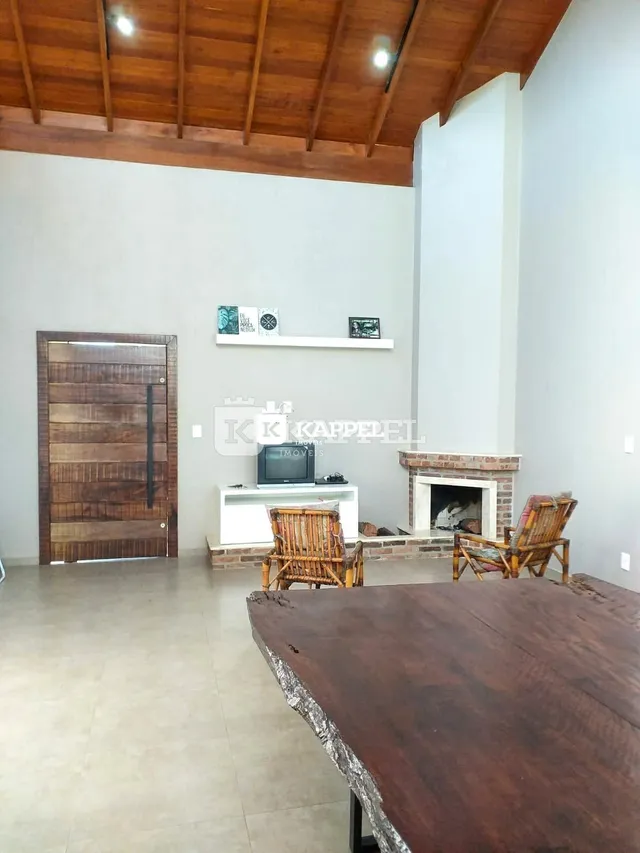 Ambiente interno com teto de madeira e lareira em uma residência.