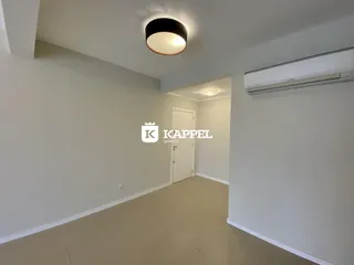 Hall de entrada com paredes brancas e piso claro.