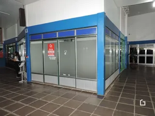 Fachada de um imóvel comercial com grandes janelas de vidro e estrutura azul.