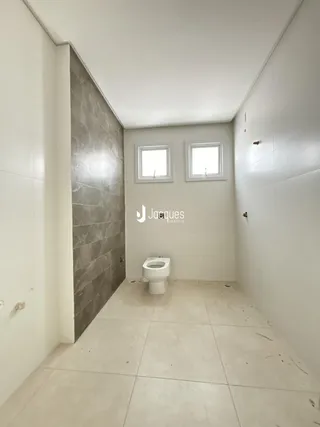 Foto de um banheiro com paredes brancas e piso claro.