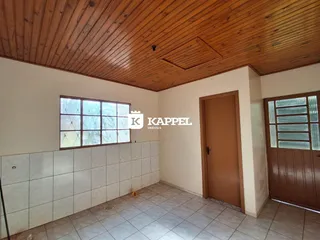 Foto interna de uma sala com piso de cerâmica e forro de madeira.