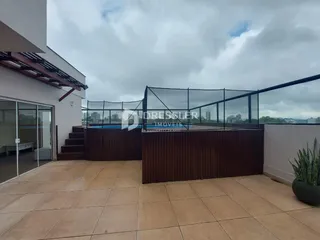 Vista da área externa com piso de cerâmica e grade de vidro.