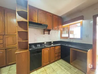 Foto de uma cozinha com armários de madeira e bancada escura.