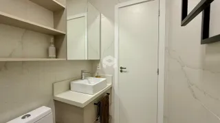 Foto de um banheiro interno com revestimento branco e bancada.