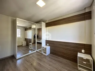 Ambiente interno de uma sala com piso de madeira e espelhos.