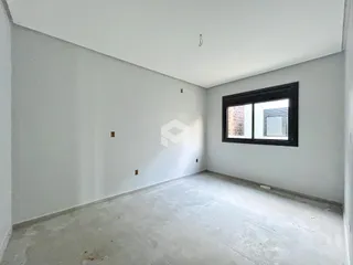 Foto de um cômodo vazio com paredes brancas e piso de concreto em uma residência.