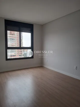 Sala de estar com piso de madeira e grande janela.