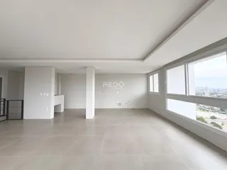 Ambiente interno amplo com piso claro e grandes janelas em uma propriedade em Lajeado.