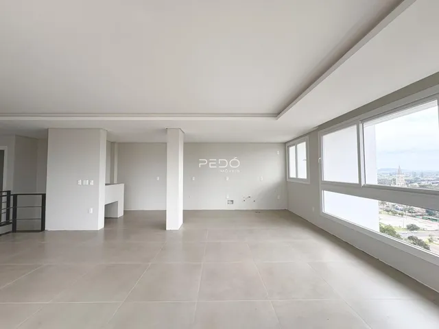 Ambiente interno amplo com piso claro e grandes janelas em uma propriedade em Lajeado.