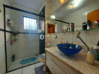 Foto de um banheiro com box de vidro e revestimento branco.
