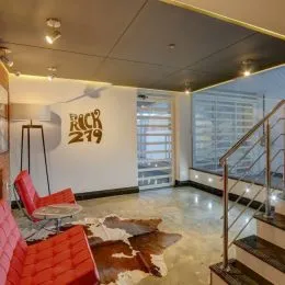 Foto de uma sala de estar com um sofá vermelho e piso claro.
