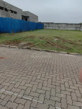 Vista externa de um terreno com gramado e cerca azul.