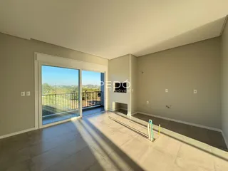 Sala ampla com vista para a paisagem através de uma grande porta de vidro.