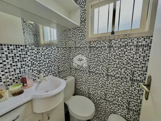 Banheiro com revestimento de azulejos pretos e brancos.
