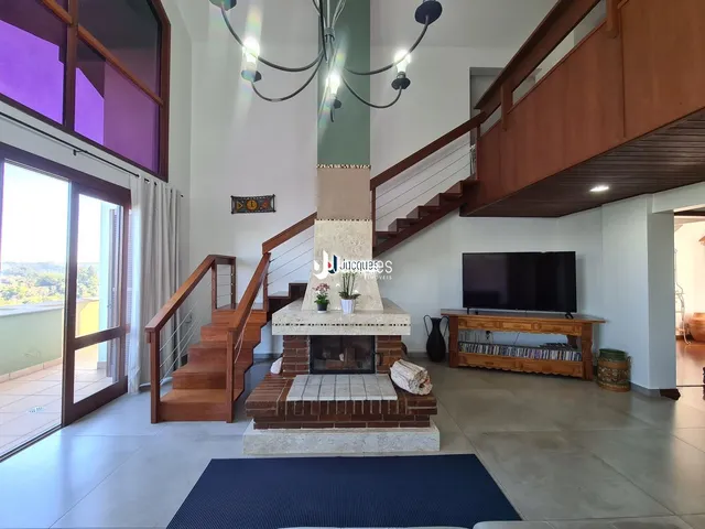 Sala de estar com lareira e escadaria em ambiente residencial.