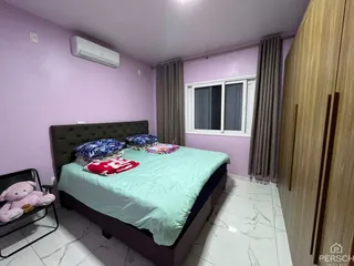 Quarto com cama grande, cortinas e ar-condicionado em um ambiente com paredes roxas.