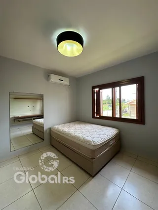 Quarto com cama e janela em uma residência.