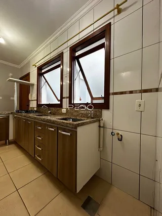 Interior de um corredor com paredes de azulejo e janela de madeira.