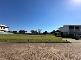 Vista externa de uma residência com jardim e área pavimentada.