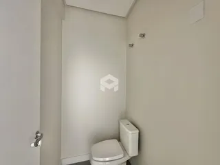Vista de um corredor interno com um banheiro visível.