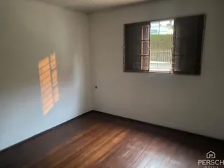 Foto de um cômodo interno com piso de madeira e uma janela.