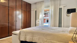 Quarto com armário de madeira e janela iluminada.