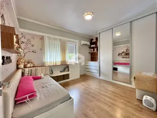 Quarto com cama e armário de parede em ambiente claro.