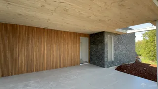 Vista de uma área externa com parede de madeira e alvenaria em construção.