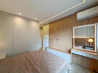 Quarto moderno com painéis de madeira e armários embutidos.