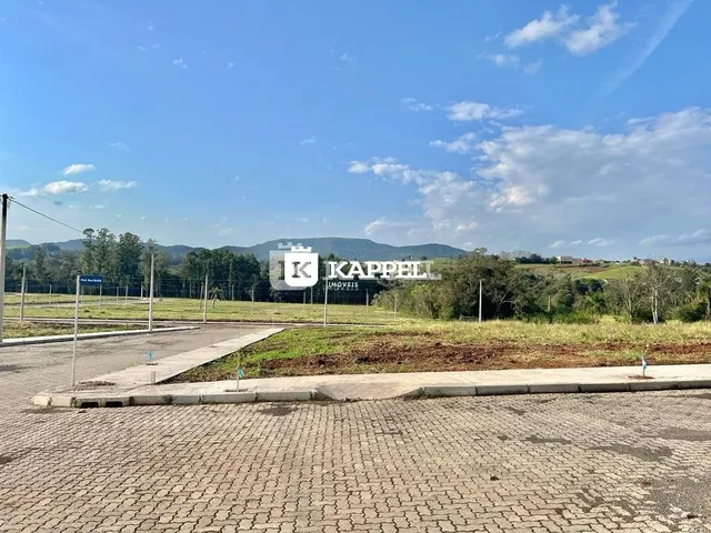 Vista externa de uma área com paisagem de colinas sob um céu azul.