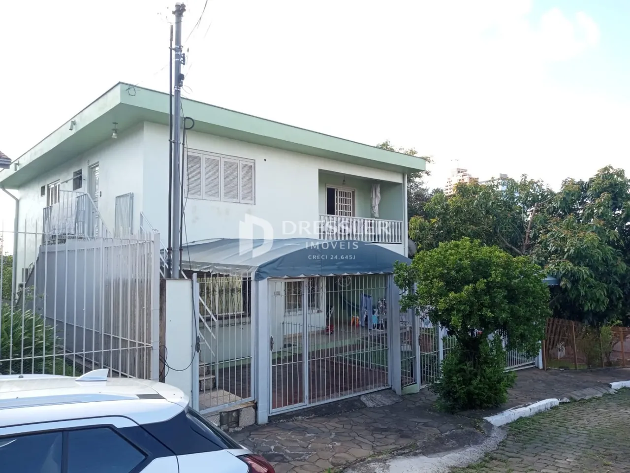 Fachada de uma residência em Lajeado, Brasil, com portão de segurança de metal.