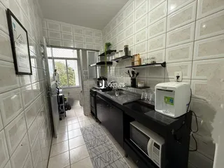Foto de uma cozinha com revestimento de cerâmica branca e armários escuros.