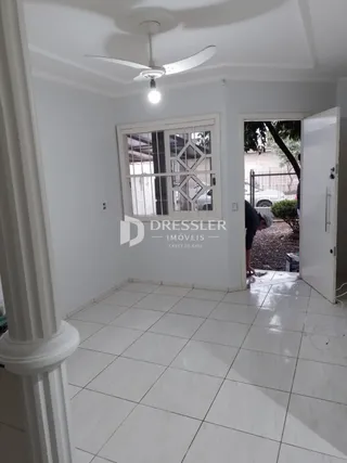 Hall com piso de cerâmica branca e paredes brancas.