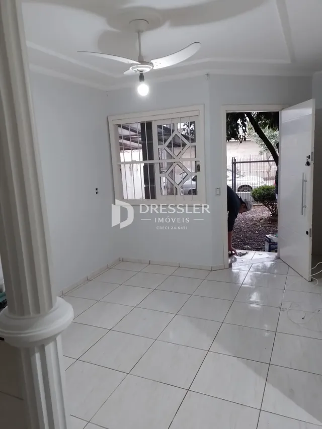 Hall com piso de cerâmica branca e paredes brancas.