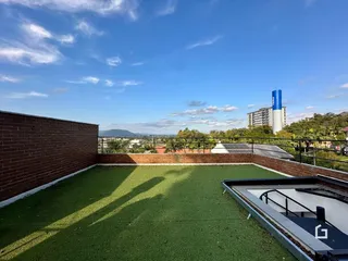 Vista de um terraço com muro de tijolos e paisagem urbana.