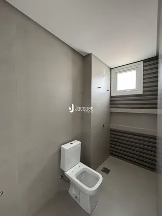 Banheiro moderno com paredes claras e piso liso.