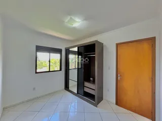 Uma sala interna clara com piso de cerâmica e um armário de madeira.