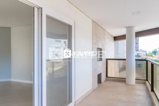 Ambiente interno com parede branca e porta de vidro que dá acesso a uma varanda.