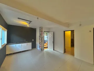 Ambiente interno de uma sala com piso claro e armários brancos.