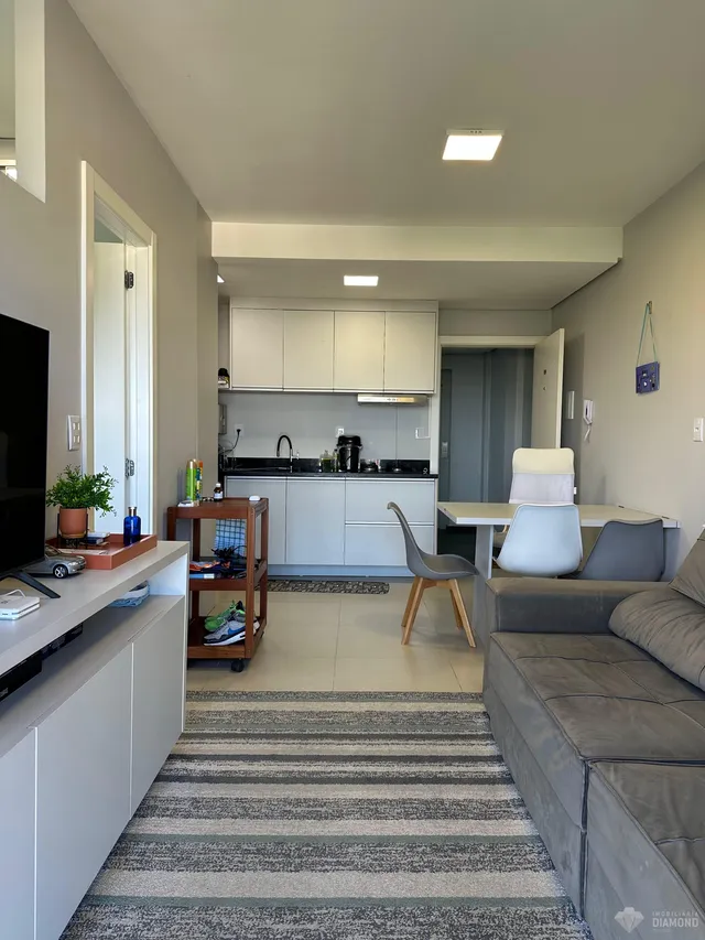 Ambiente moderno de sala de estar e cozinha em um apartamento no Brasil.
