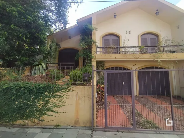 Fachada de uma residência em Lajeado, Brasil, com cerca e vegetação.