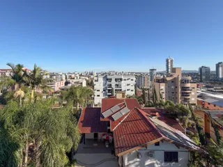 Vista aérea de um imóvel com telhado de telhas vermelhas e vegetação exuberante.